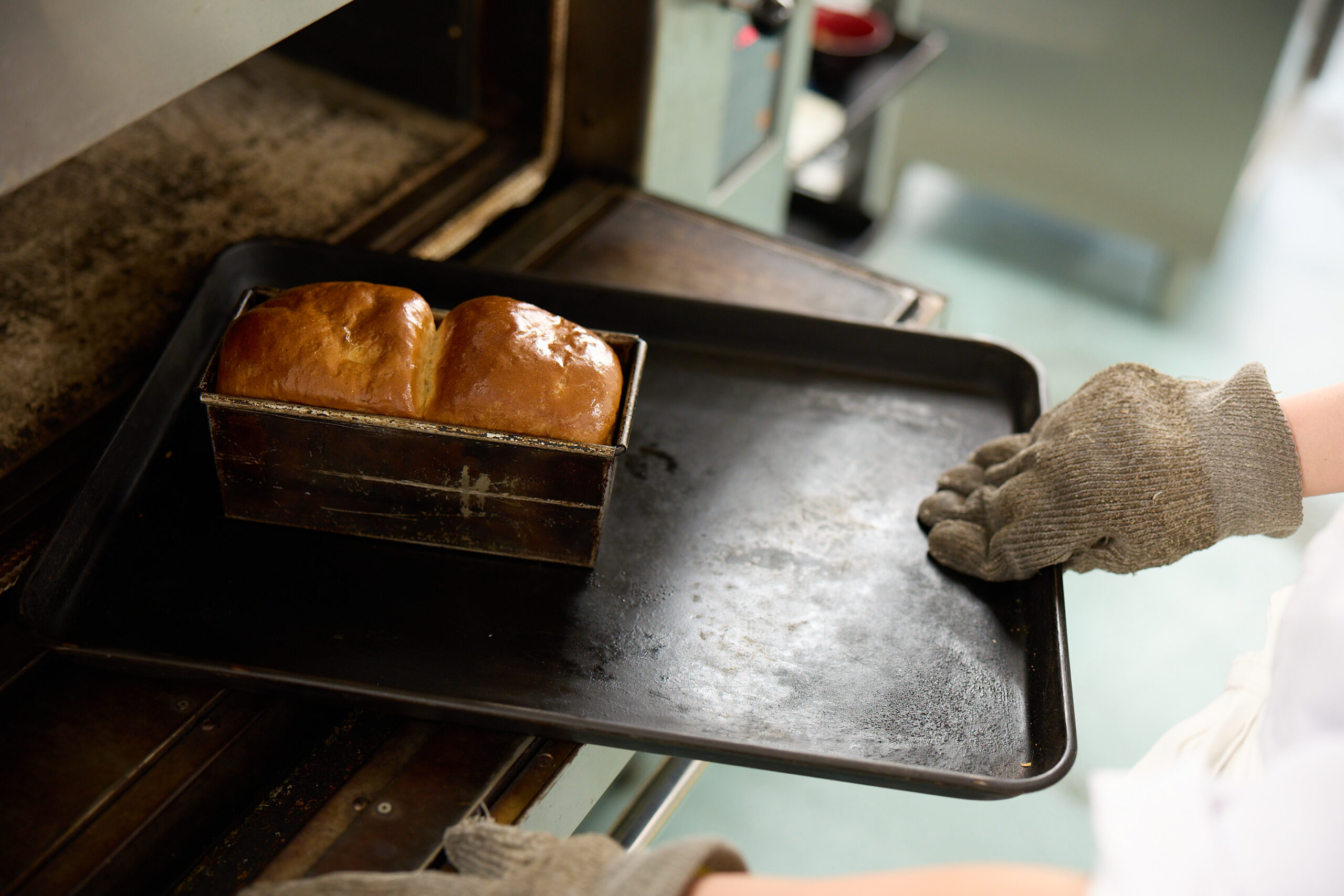 施設での食事準備。スタッフがパンを焼き上げている調理風景。